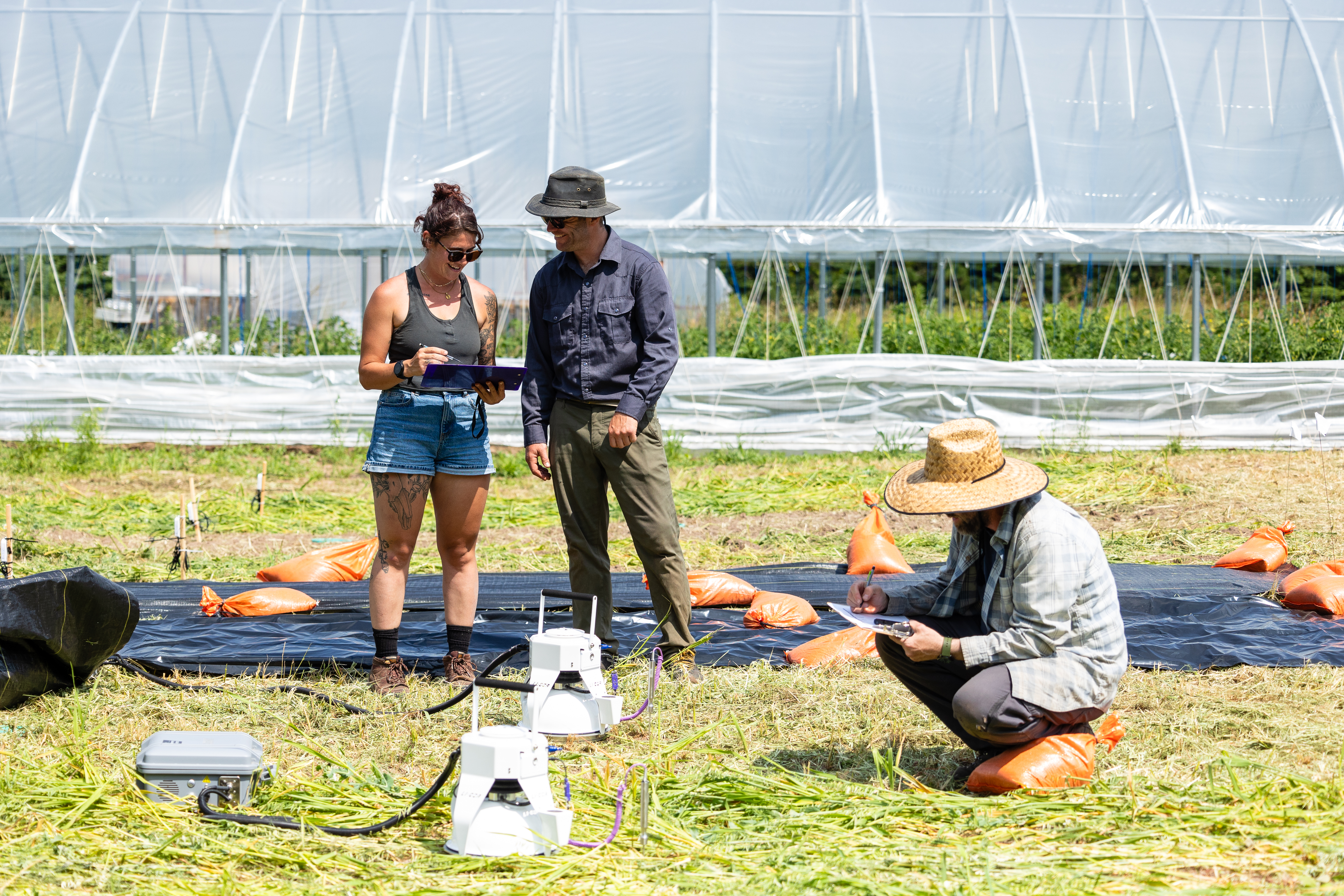 "Photo taken of two NMU-ABL student research technicians collecting greenhouse gas emission measurements in an experimental cover crop termination study plot at MSU-UPREC.